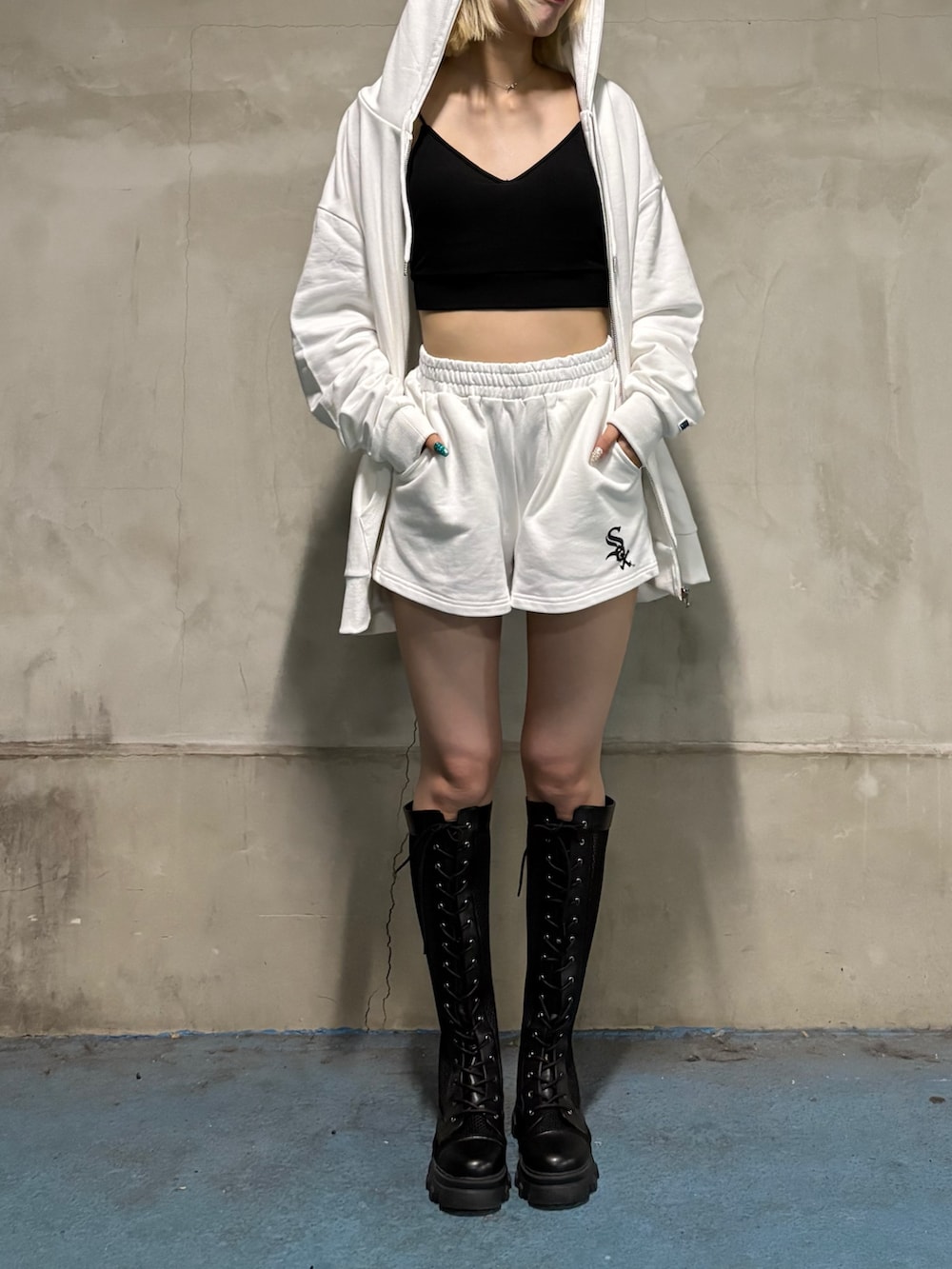 ホワイト系のワンピース、ブラック系のブーツを着用したレディースの夏コーディネートの2枚目の写真