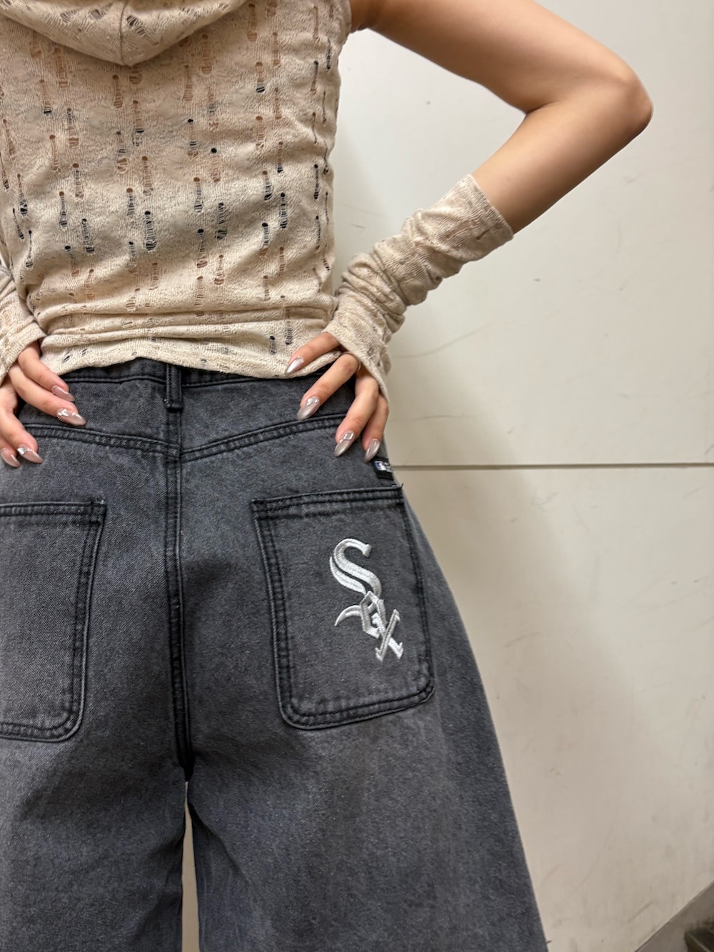 ブラック系のデニムパンツ、ベージュ系のニット/セーター、ブラック系のニットキャップ/ビーニーを着用したレディースの春コーディネートの3枚目の写真
