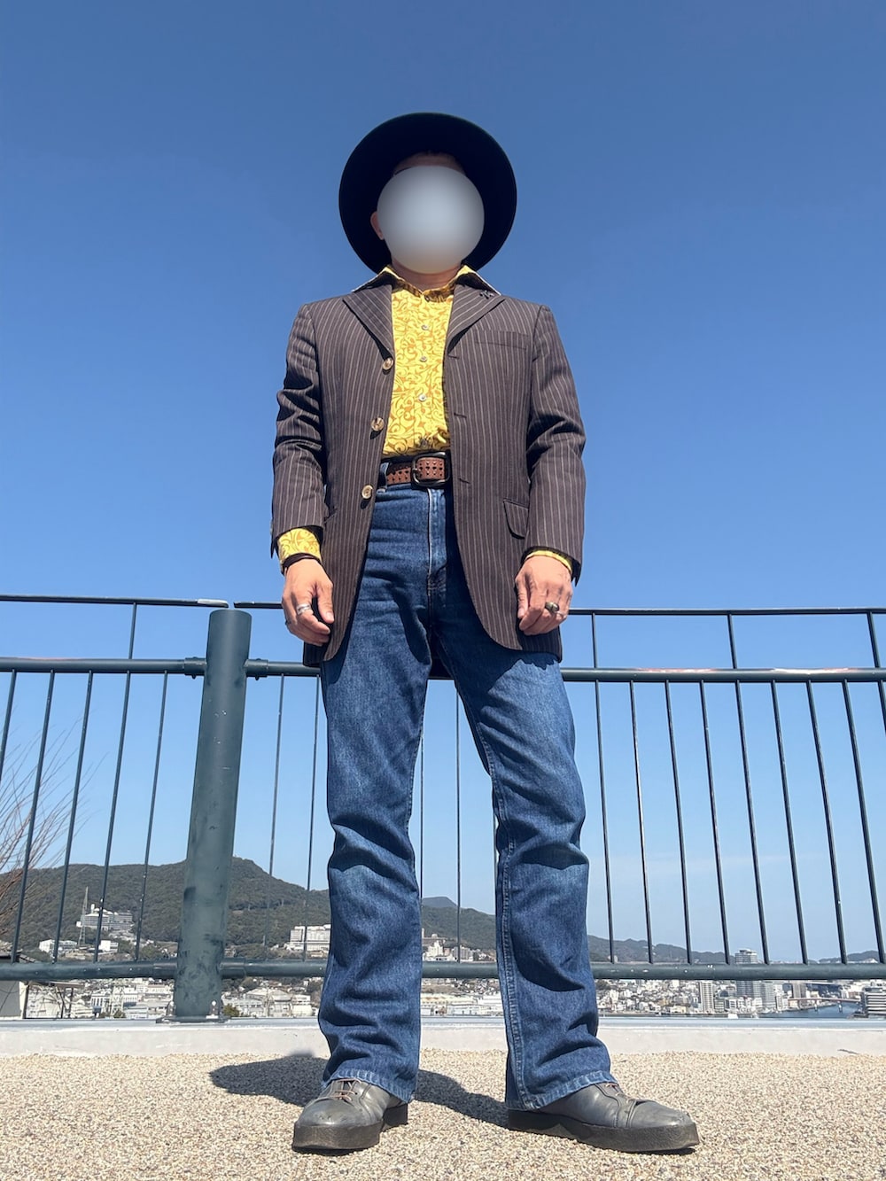 ブルー系のデニムパンツ、グリーン系のブーツ、イエロー系のシャツ/ブラウスを着用したメンズの春コーディネートの2枚目の写真