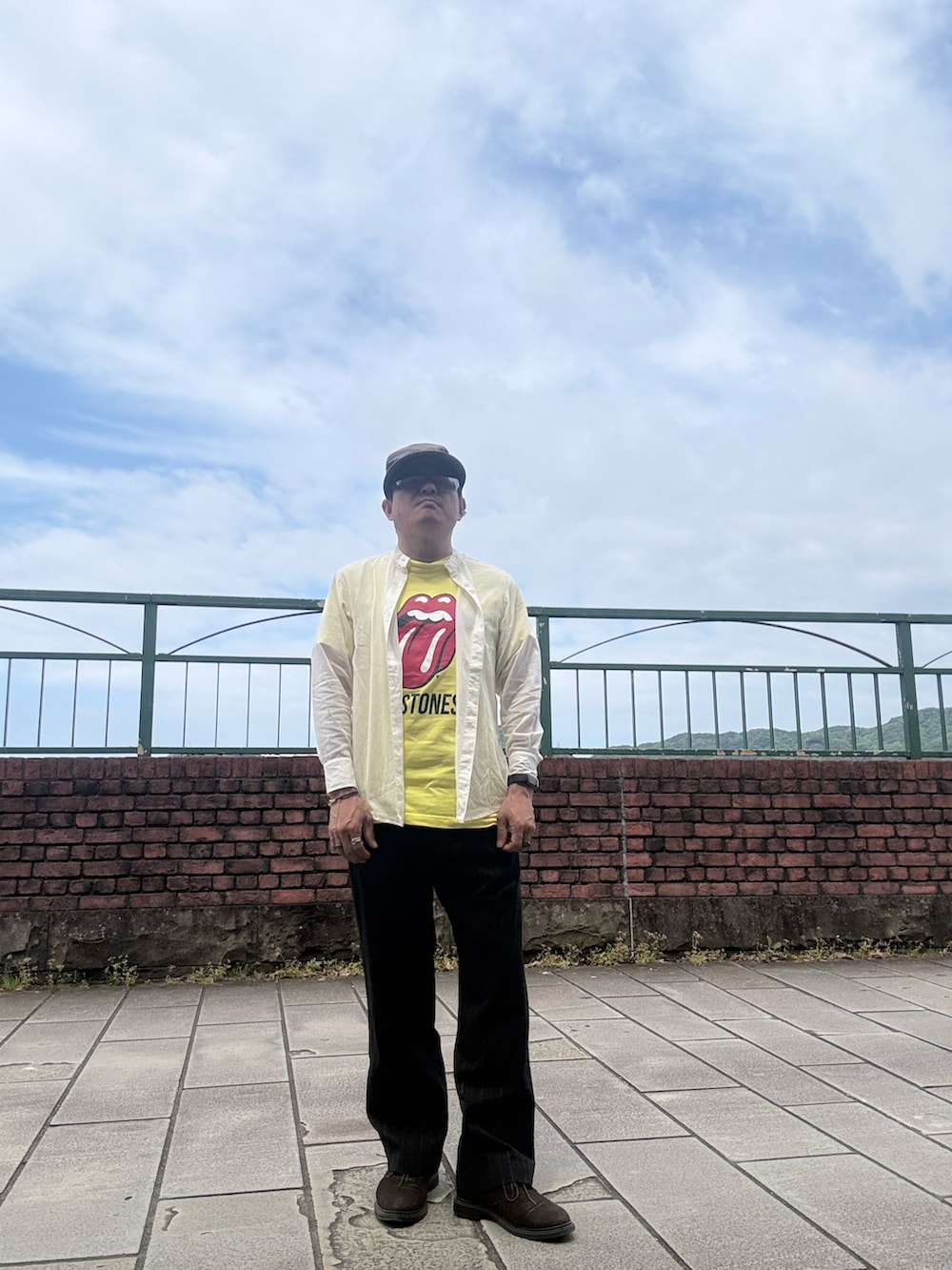 ベージュ系のシャツ/ブラウス、イエロー系のTシャツ/カットソー、ブラック系のスラックスを着用したメンズの春コーディネートの3枚目の写真