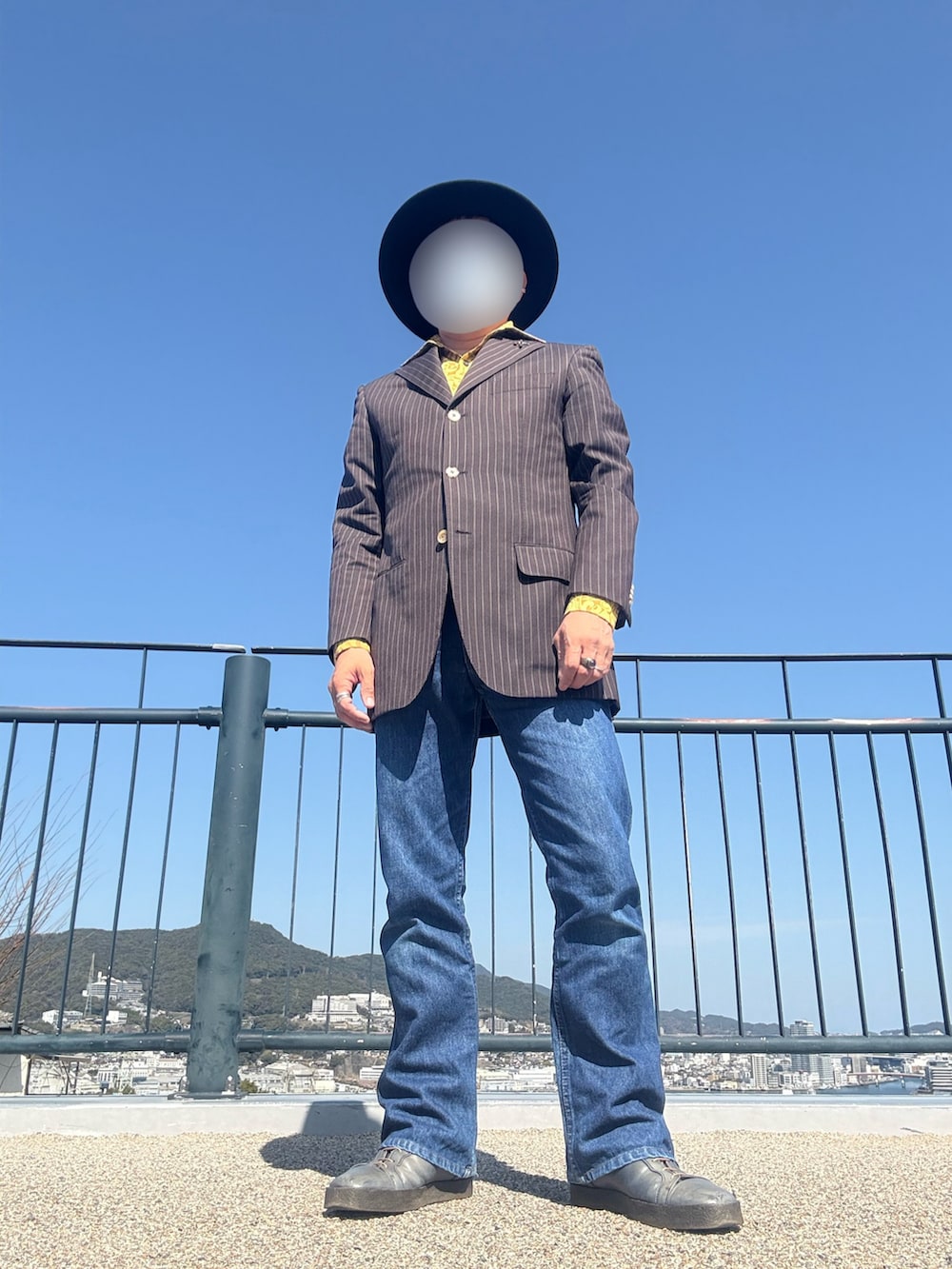 ブルー系のデニムパンツ、グリーン系のブーツ、イエロー系のシャツ/ブラウスを着用したメンズの春コーディネートの3枚目の写真