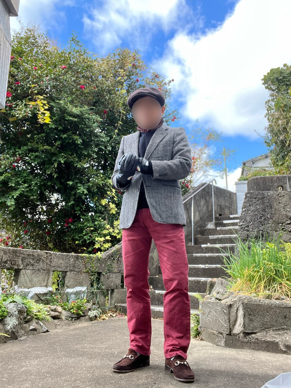 レッド系のデニムパンツ、ブラウン系のローファー、グレー系のテーラードジャケットを着用したメンズの冬コーディネートの2枚目の写真