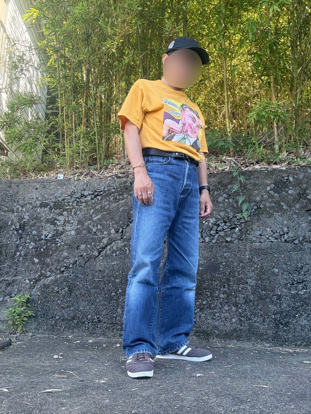 イエロー系のTシャツ/カットソー、ブルー系のデニムパンツ、ブラウン系のスニーカーを着用したメンズの夏コーディネートの2枚目の写真