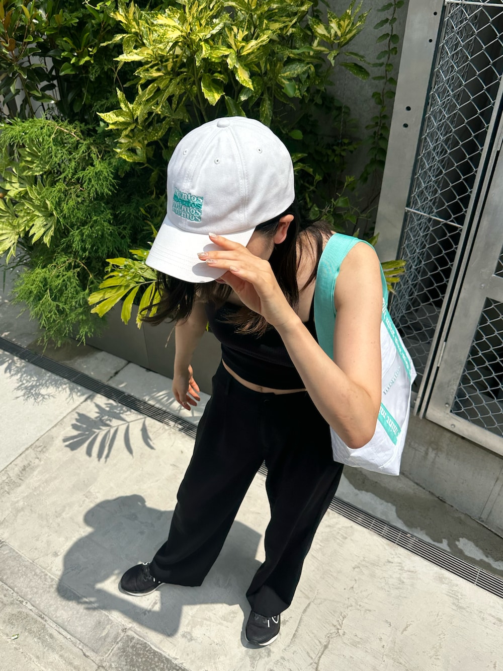 「夏コーデ、さらっと晴れやかスナップ、大人カジュアル、ラフコーデ、骨格ナチュラル、ブルベ夏、ブラックコーデ、黒パンツ、黒スニーカー、白キャップ」｜「BIRTHDAY BARのmentos レジャートートバッグ（トートバッグ、ブルー系）」を使った、Konomiさん（骨格ナチュラル・レディース・170cm）の夏コーディネートの2枚目の写真