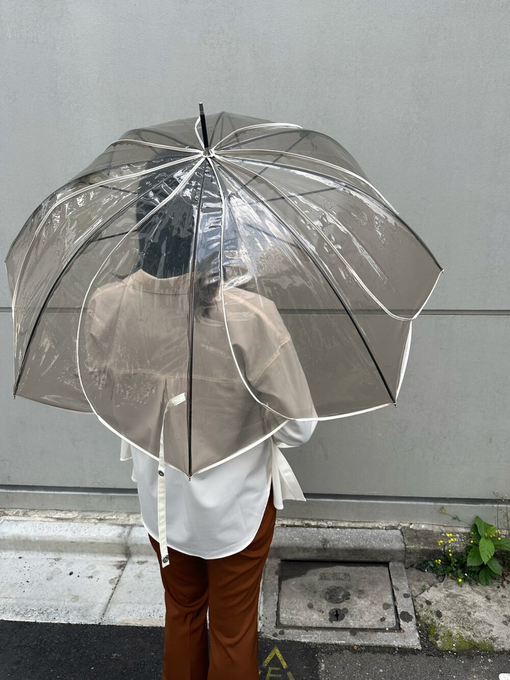 「シンプルスタイル、雨の日コーデ、白シャツ、ブラウンパンツ、高身長、骨格ナチュラル、高身長コーデ」｜「Actuallyのクリアアンブレラ カラーパイピング（長傘、ブラウン系）」を使った、Konomiさん（骨格ナチュラル・レディース・170cm）の春コーディネートの3枚目の写真