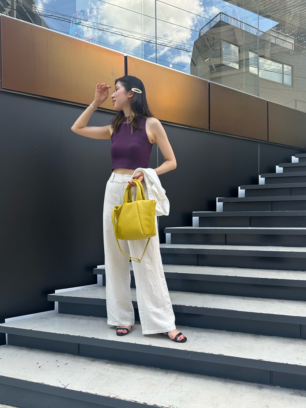 イエロー系のトートバッグ、パープル系のタンクトップを着用したレディースの夏コーディネートの2枚目の写真