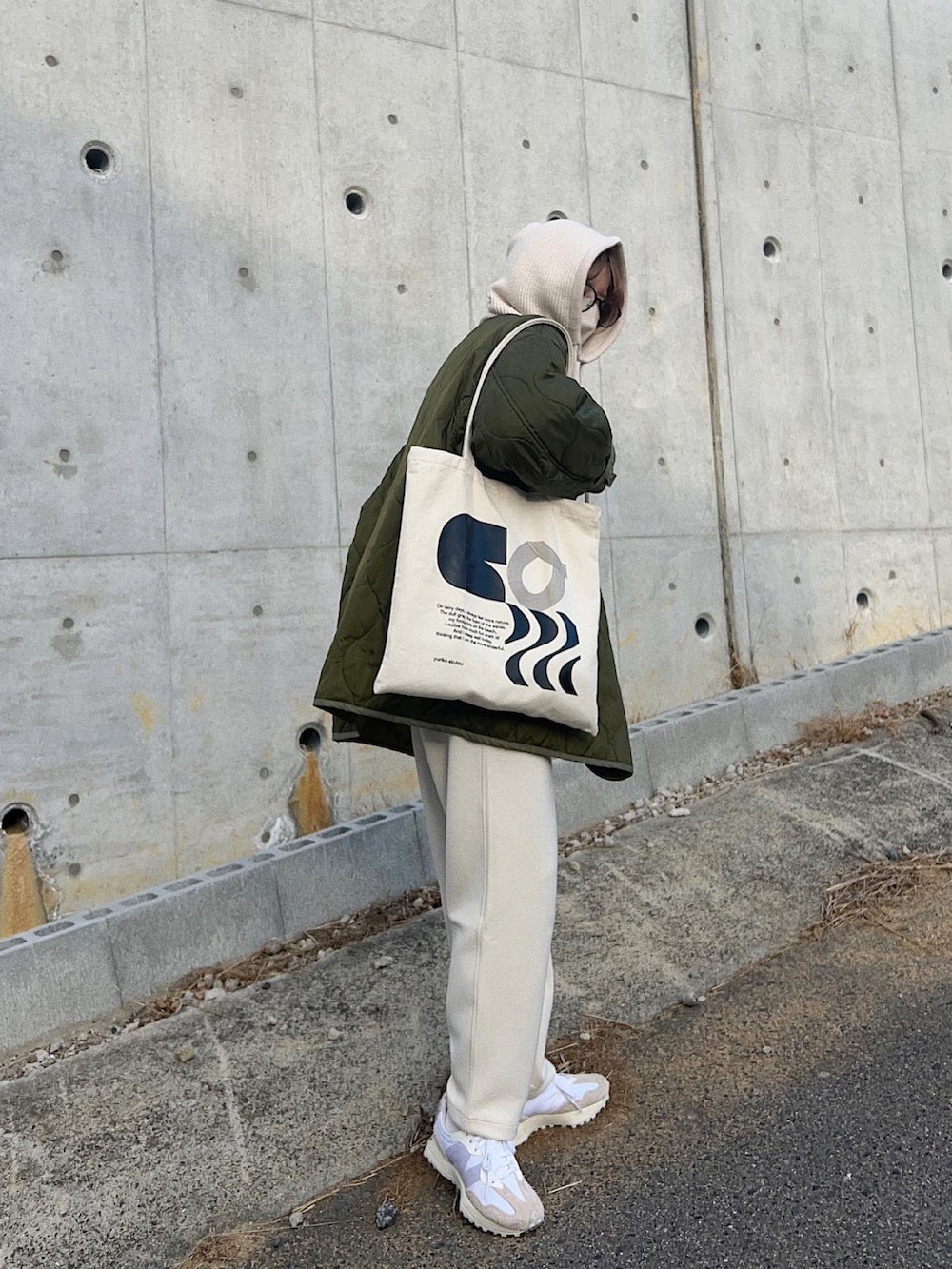 グリーン系のノーカラージャケット、ホワイト系のスニーカー、ホワイト系のマフラーを着用したレディースの春コーディネートの2枚目の写真