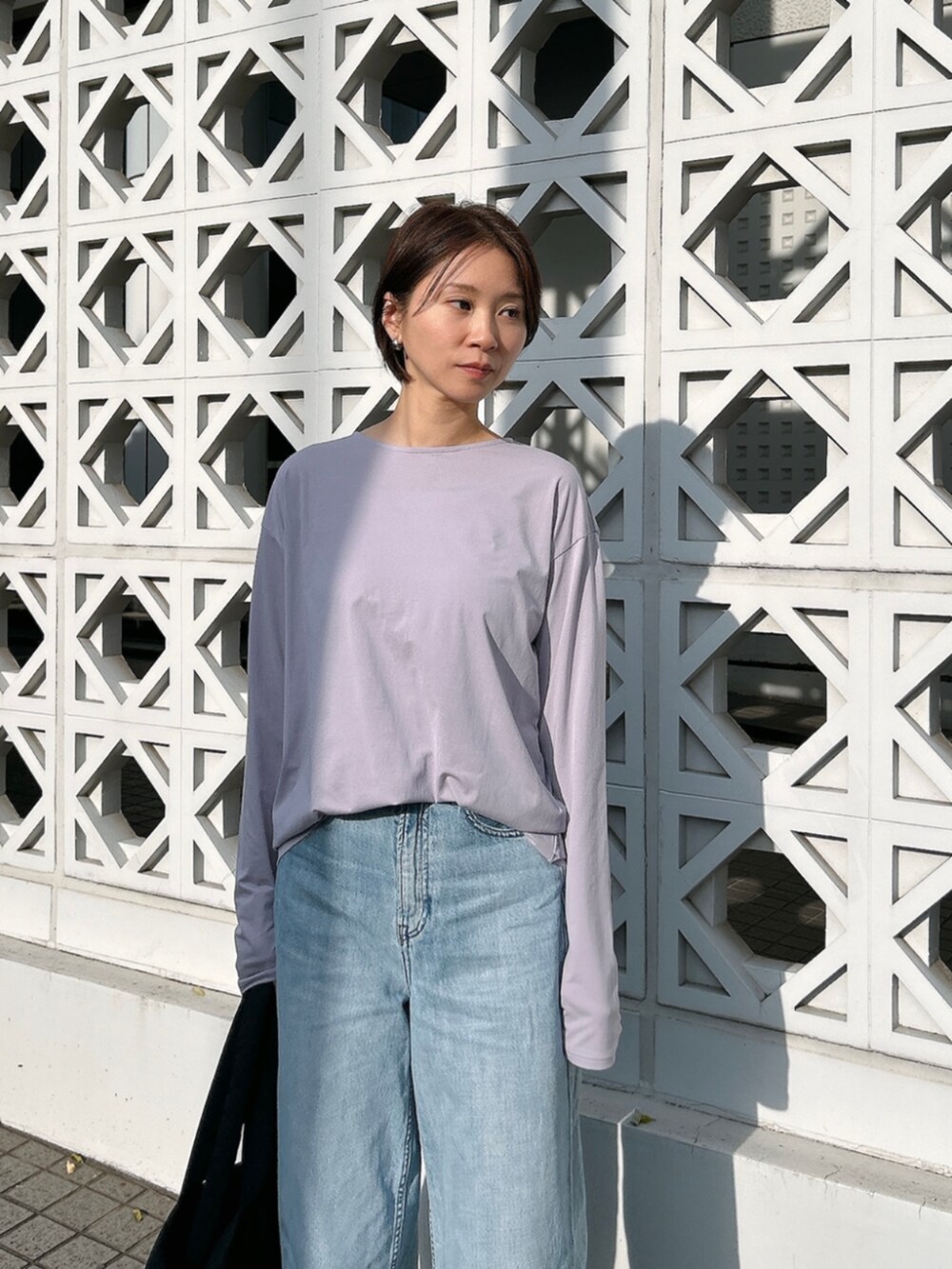 ブラック系のトートバッグ、パープル系のTシャツ/カットソーを着用したレディースの春コーディネートの3枚目の写真