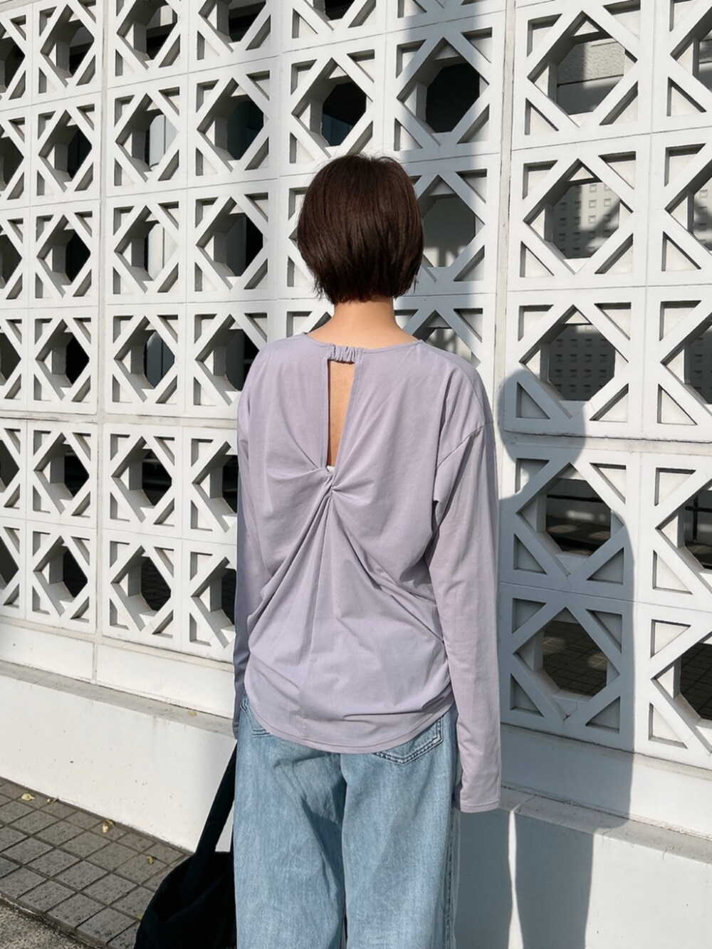 ブラック系のトートバッグ、パープル系のTシャツ/カットソーを着用したレディースの春コーディネートの4枚目の写真