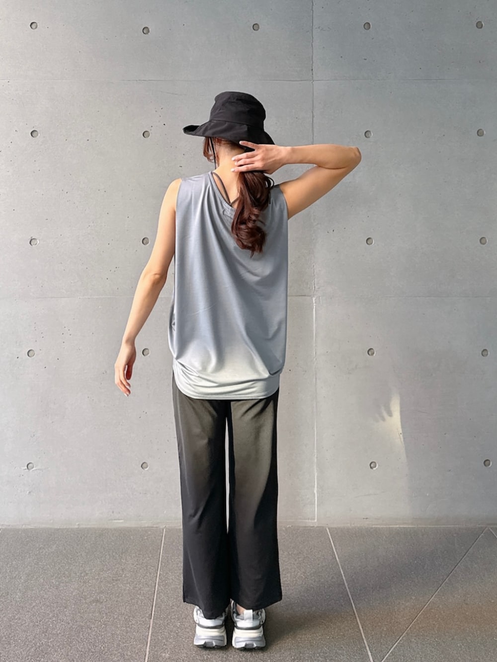 グレー系のタンクトップ、ブラック系のレギンス/スパッツを着用したレディースの春コーディネートの3枚目の写真