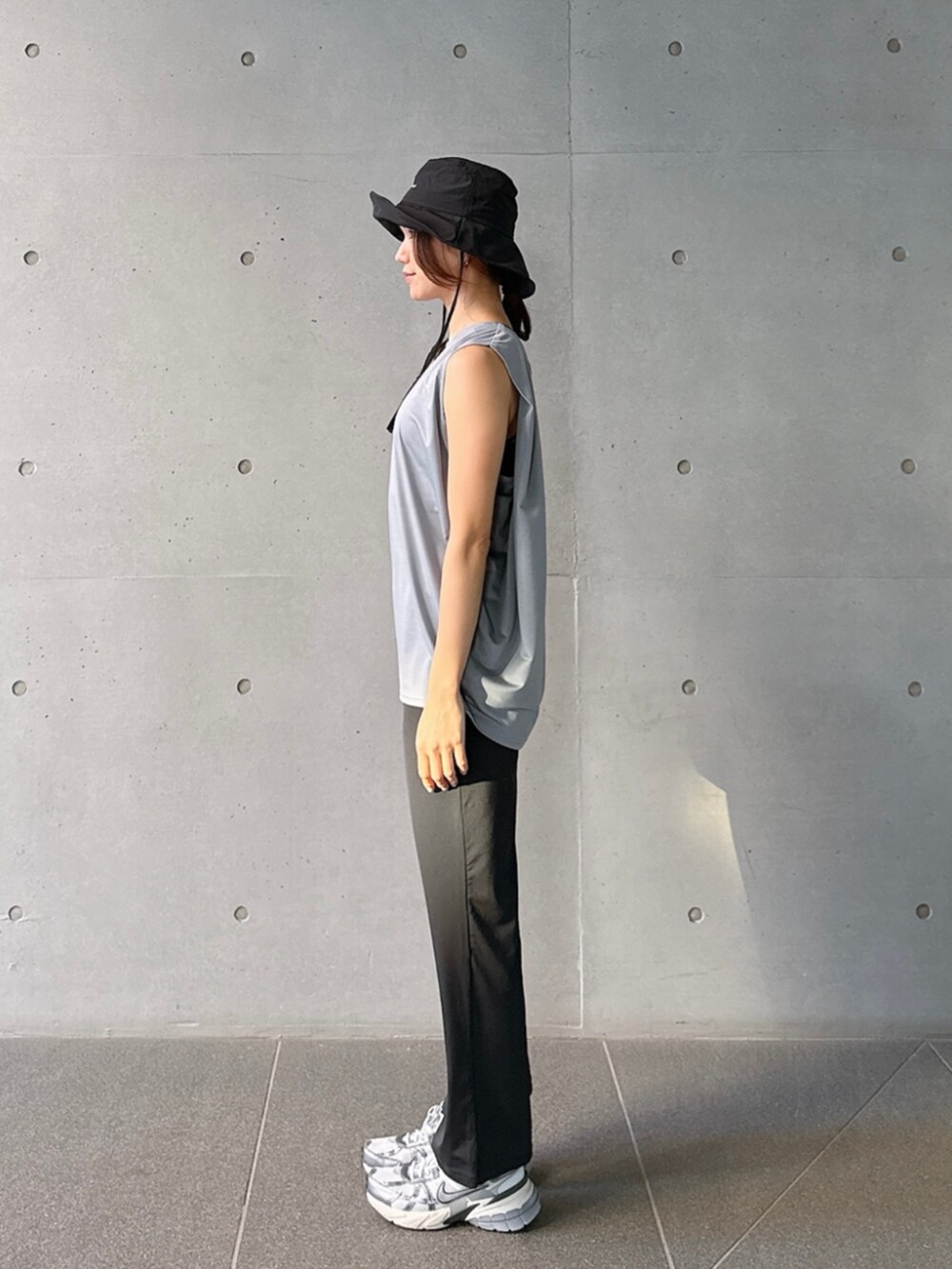 グレー系のタンクトップ、ブラック系のレギンス/スパッツを着用したレディースの春コーディネートの2枚目の写真
