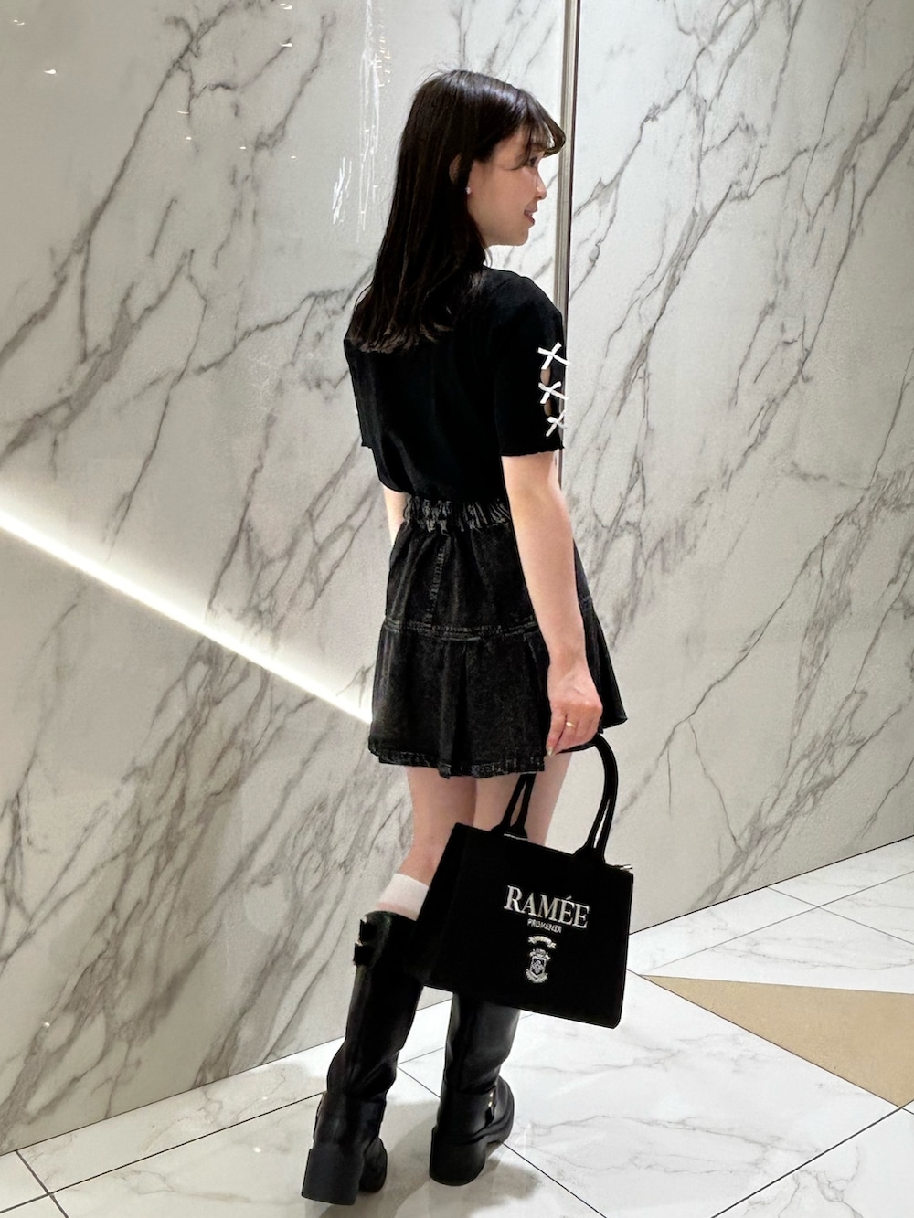 ブラック系のバッグ、ブラック系のTシャツ/カットソー、ブラック系のスカートを着用したレディースの春コーディネートの3枚目の写真