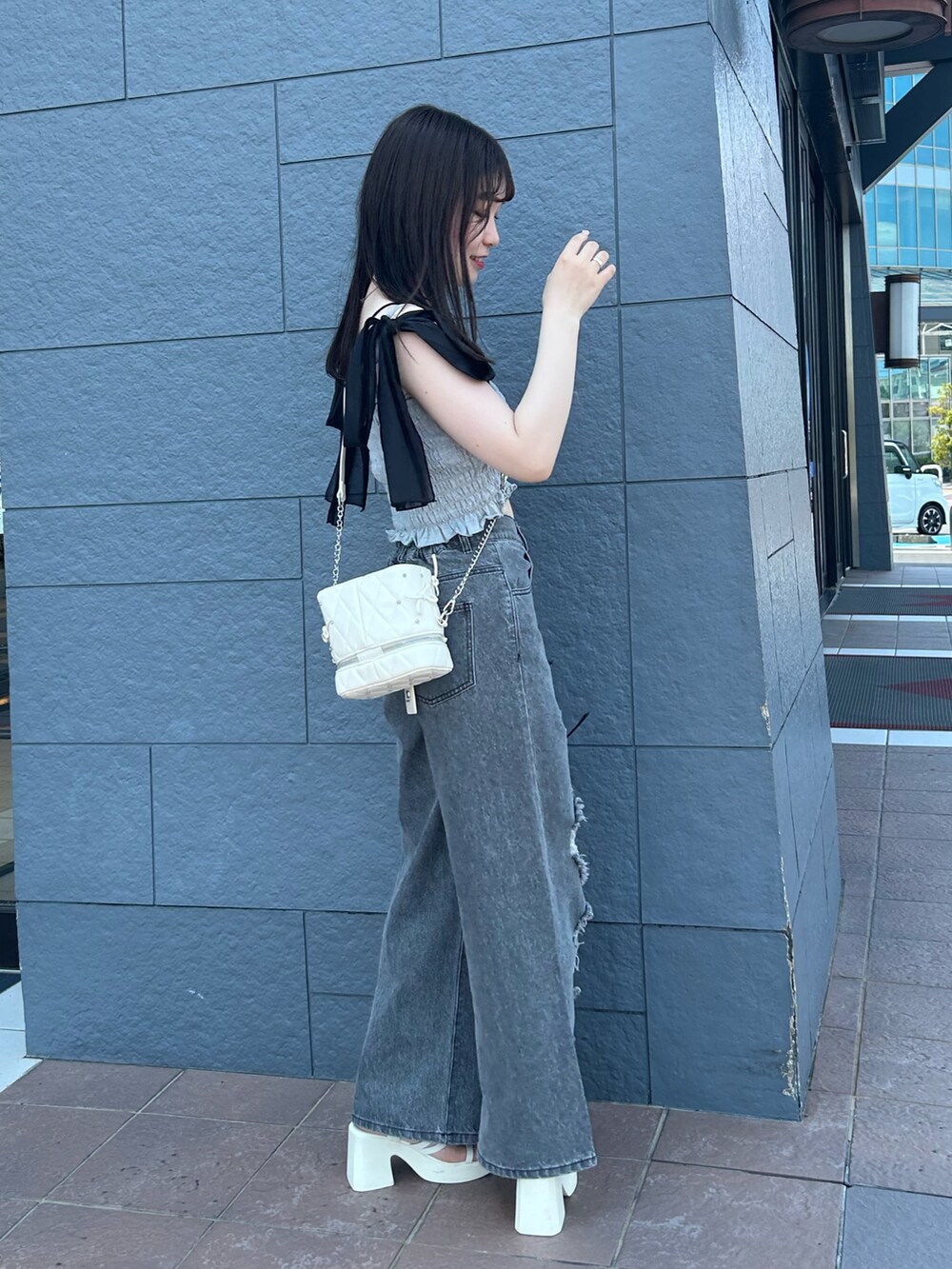 グレー系のその他トップス、ブラック系のデニムパンツ、ホワイト系のショルダーバッグを着用したレディースの夏コーディネートの2枚目の写真