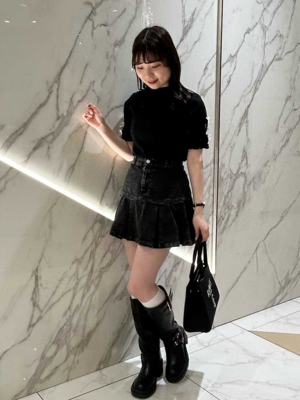 ブラック系のバッグ、ブラック系のTシャツ/カットソー、ブラック系のスカートを着用したレディースの春コーディネートの2枚目の写真