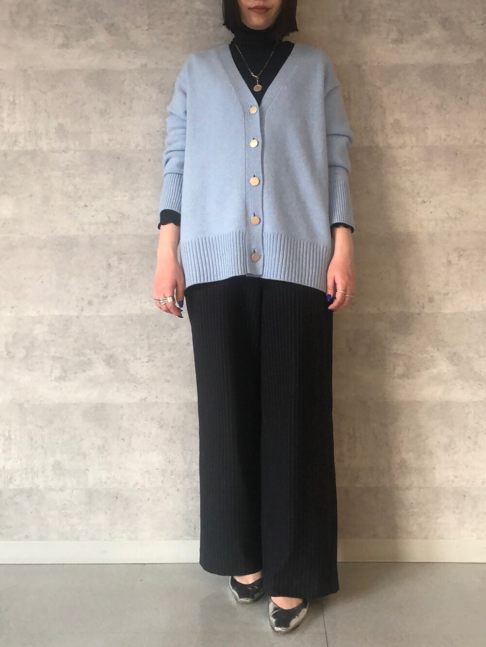 ブルー系のTシャツ/カットソー、ブルー系のカーディガン/ボレロ、ブラック系のショルダーバッグを着用したレディースの冬コーディネートの7枚目の写真