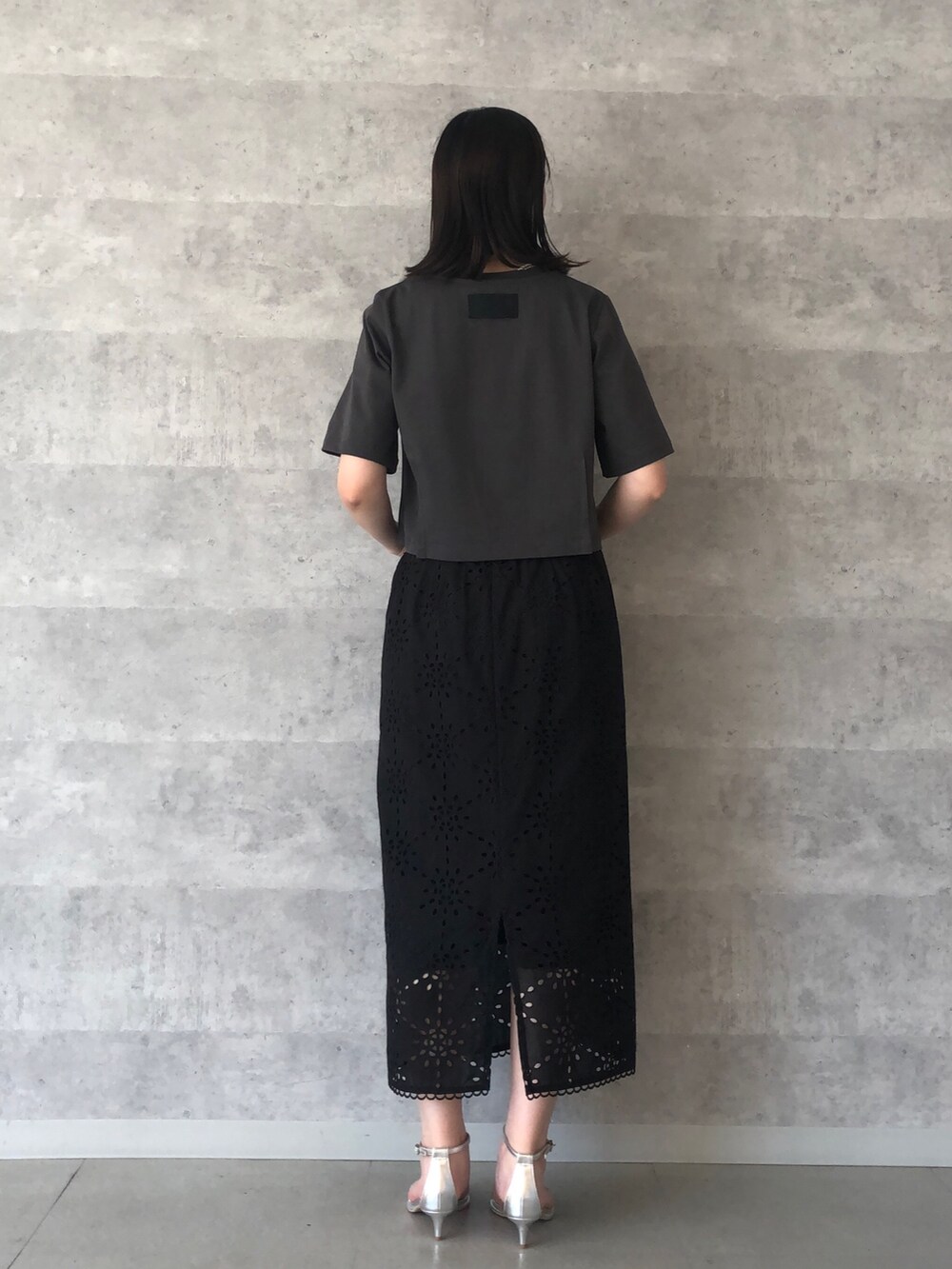 グレー系のTシャツ/カットソー、ゴールド系のショルダーバッグ、ブラック系のスカートを着用したレディースの夏コーディネートの3枚目の写真