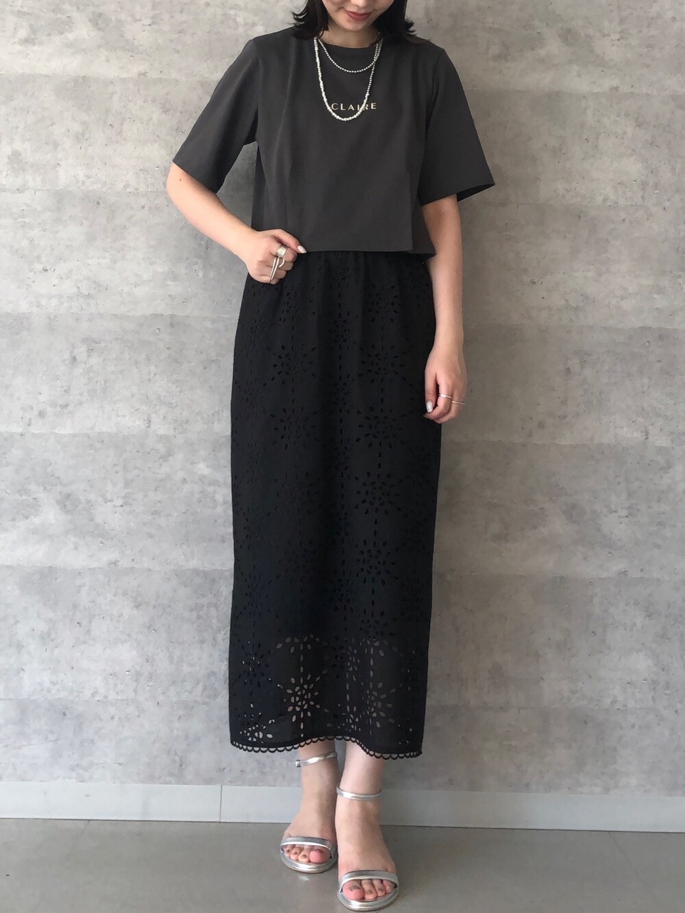 グレー系のTシャツ/カットソー、ゴールド系のショルダーバッグ、ブラック系のスカートを着用したレディースの夏コーディネートの5枚目の写真