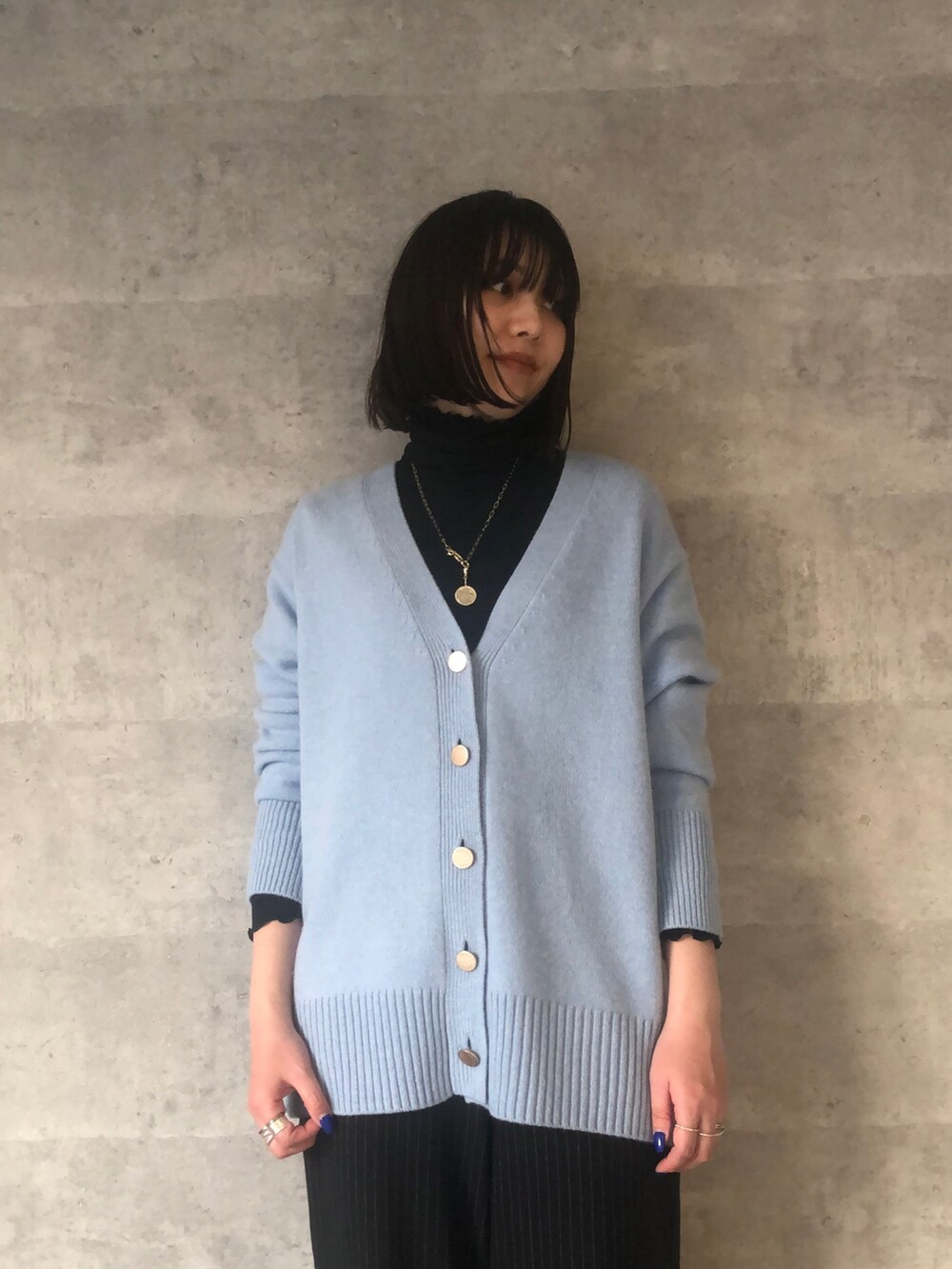 ブルー系のTシャツ/カットソー、ブルー系のカーディガン/ボレロ、ブラック系のショルダーバッグを着用したレディースの冬コーディネートの6枚目の写真