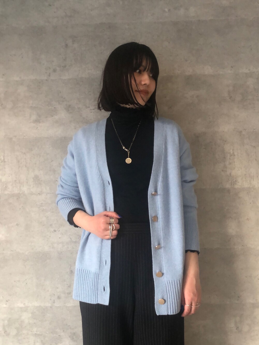 ブルー系のTシャツ/カットソー、ブルー系のカーディガン/ボレロ、ブラック系のショルダーバッグを着用したレディースの冬コーディネートの5枚目の写真