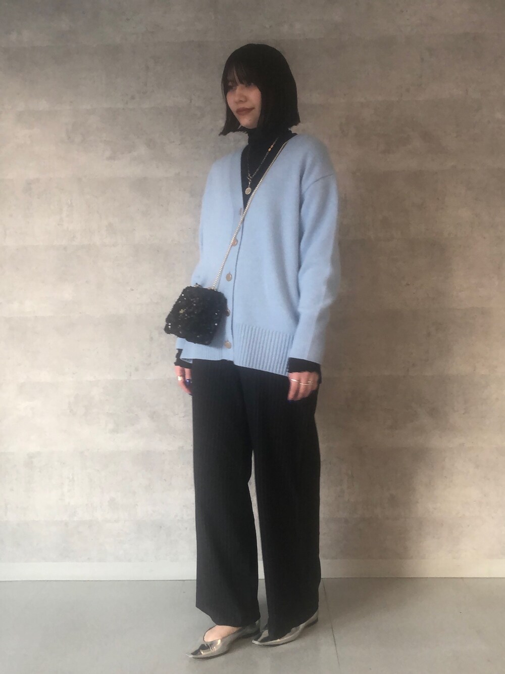 ブルー系のTシャツ/カットソー、ブルー系のカーディガン/ボレロ、ブラック系のショルダーバッグを着用したレディースの冬コーディネートの2枚目の写真