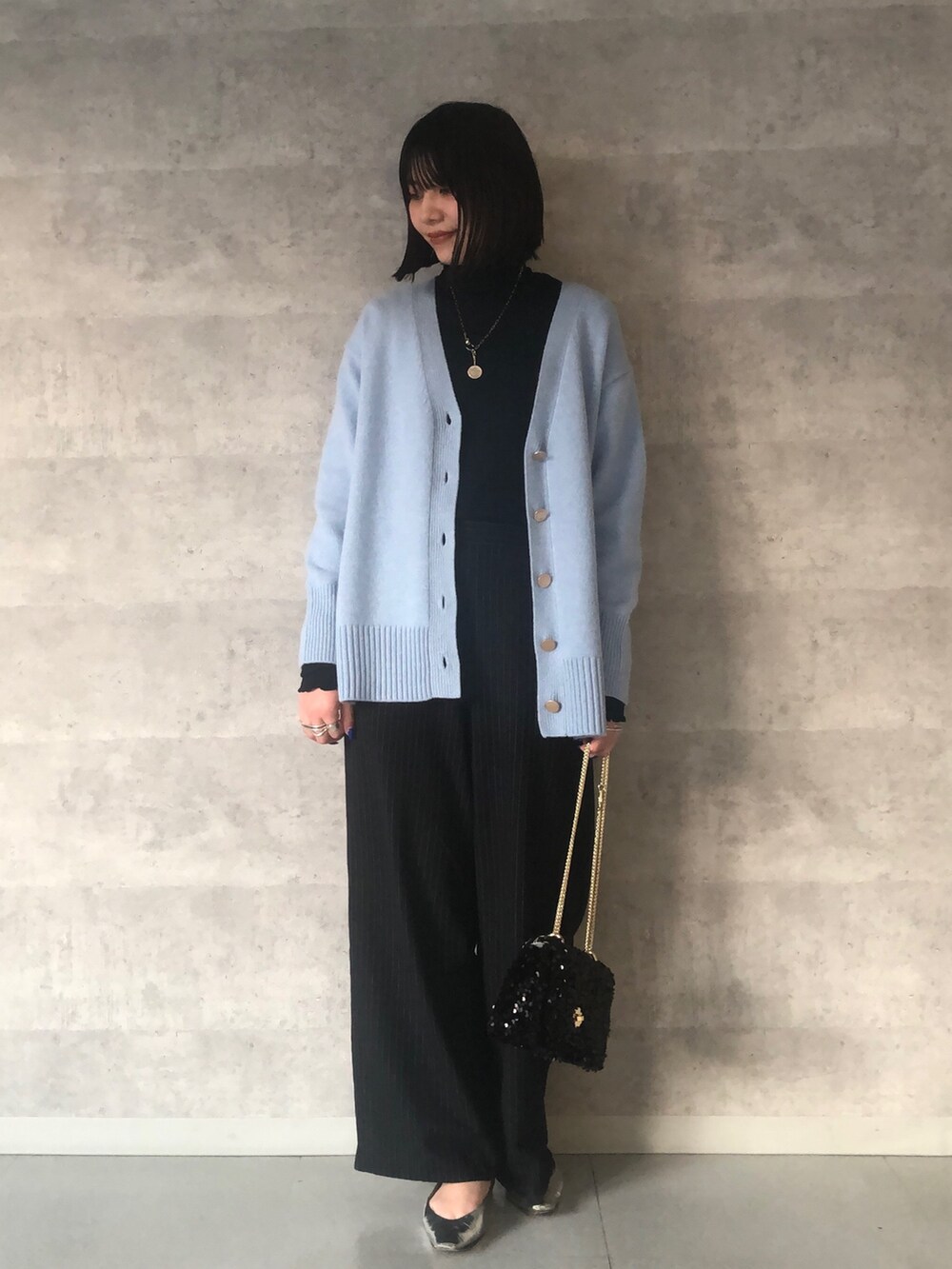 ブルー系のTシャツ/カットソー、ブルー系のカーディガン/ボレロ、ブラック系のショルダーバッグを着用したレディースの冬コーディネートの4枚目の写真