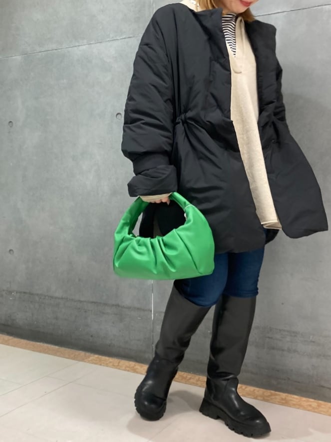 ブラック系のダウンジャケット/コート、ベージュ系のニット/セーター、ホワイト系のTシャツ/カットソーを着用したレディースの冬コーディネートの2枚目の写真