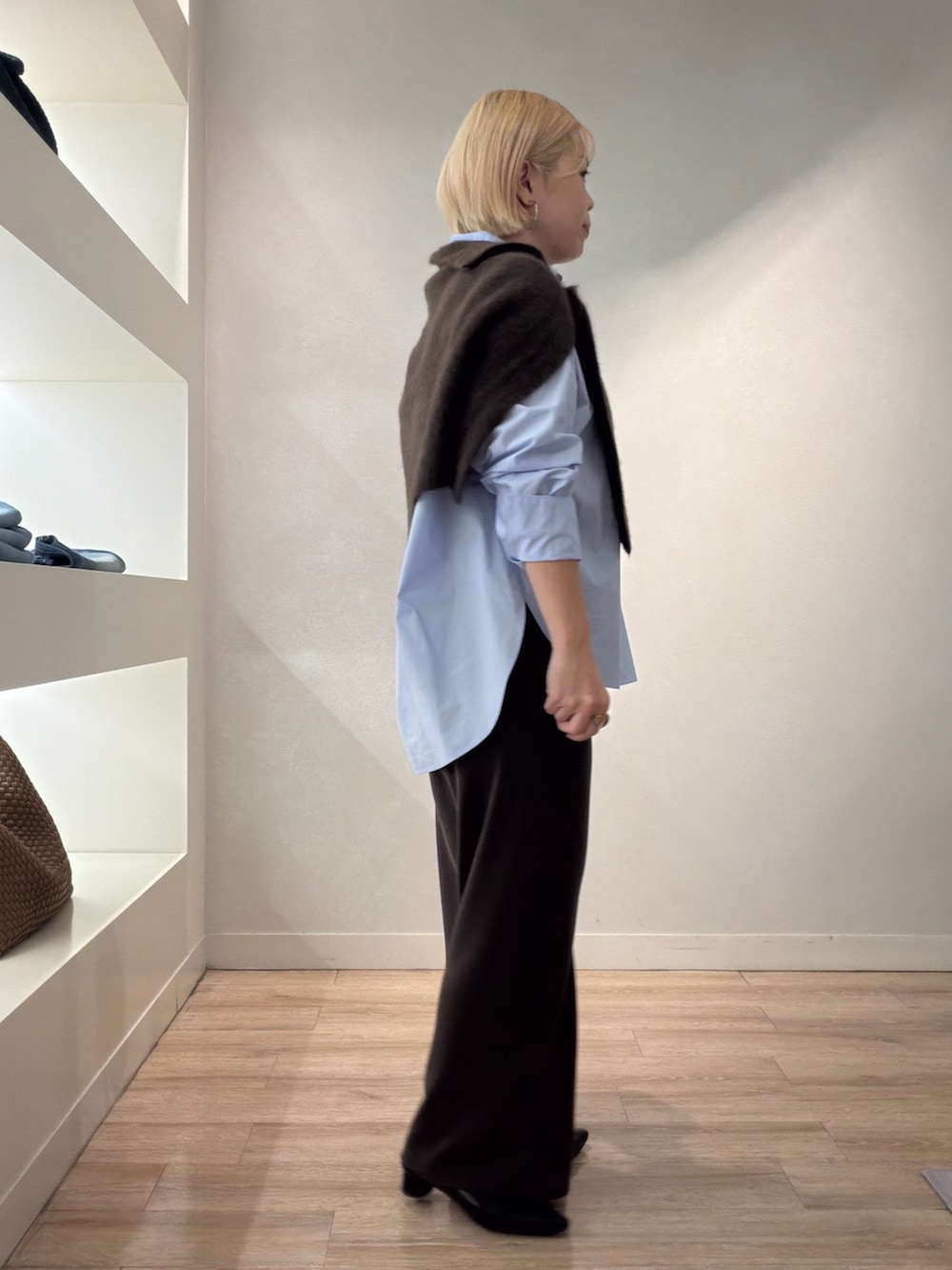 ブラウン系のニット/セーター、ブルー系のシャツ/ブラウス、ブラウン系のその他パンツを着用したレディースの秋コーディネートの3枚目の写真