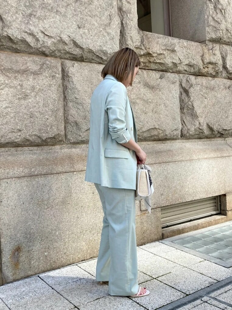 グリーン系のテーラードジャケット、グリーン系のその他パンツ、ホワイト系のタンクトップを着用したレディースの春コーディネートの2枚目の写真