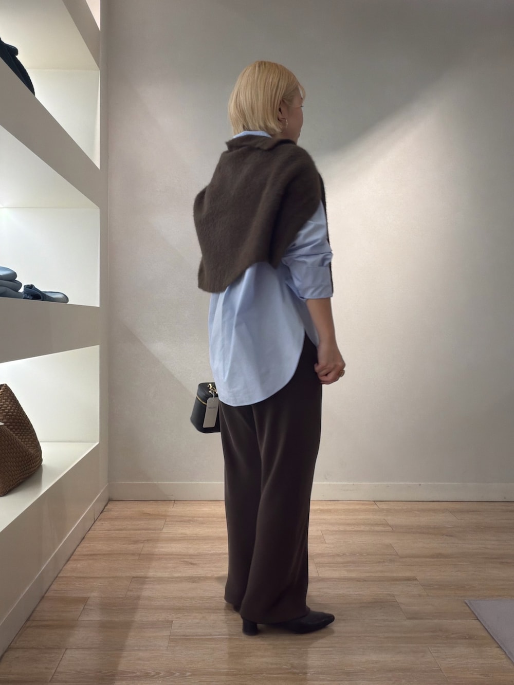 ブラウン系のニット/セーター、ブルー系のシャツ/ブラウス、ブラウン系のその他パンツを着用したレディースの秋コーディネートの4枚目の写真