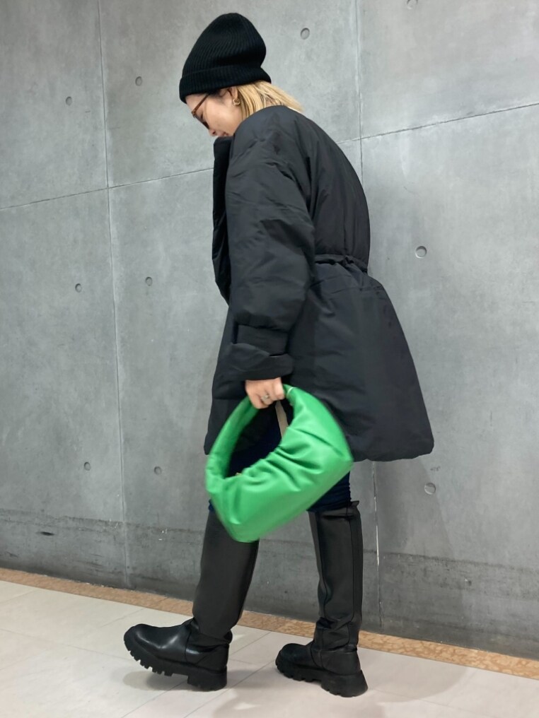 ブラック系のダウンジャケット/コート、ベージュ系のニット/セーター、ホワイト系のTシャツ/カットソーを着用したレディースの冬コーディネートの3枚目の写真