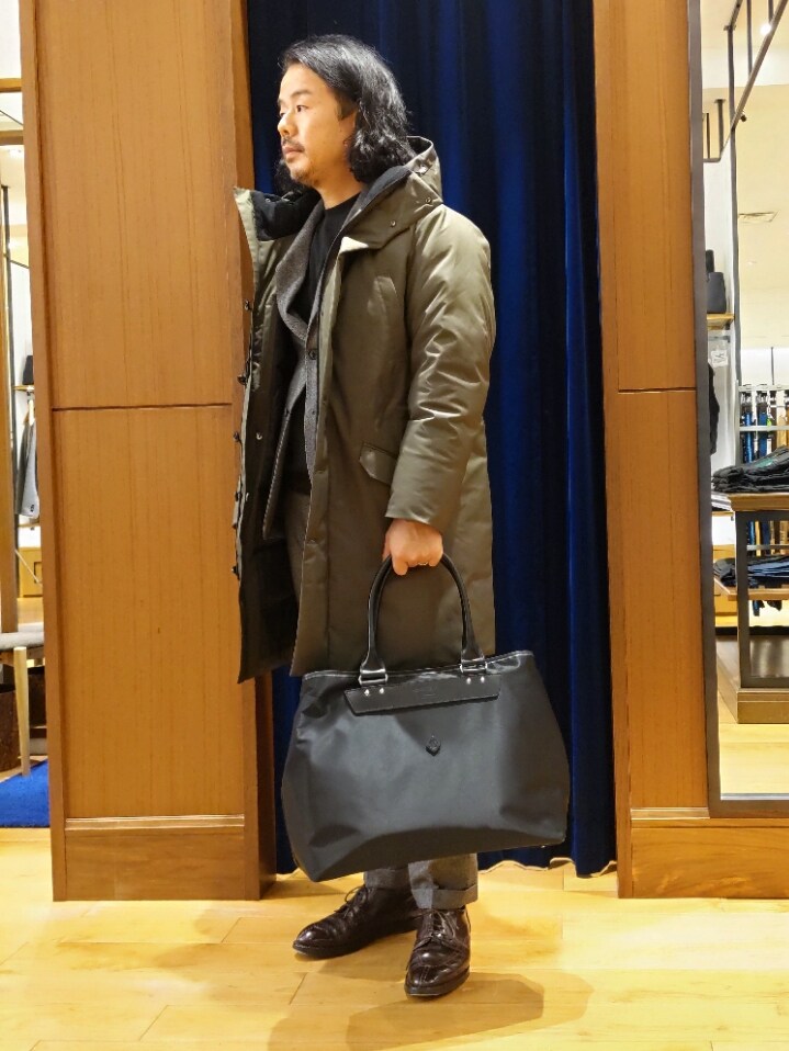 グリーン系のダウンジャケット/コート、グレー系のテーラードジャケット、グレー系のスラックスを着用したメンズの冬コーディネートの5枚目の写真