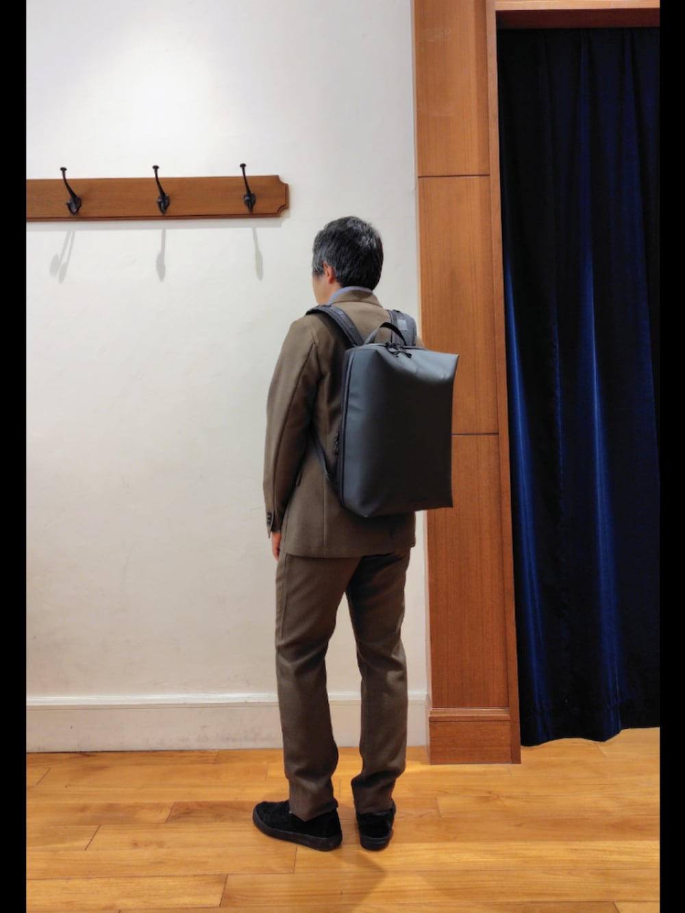 ブラック系のバックパック/リュック、グリーン系のテーラードジャケット、グリーン系のその他パンツを着用したメンズの春コーディネートの6枚目の写真