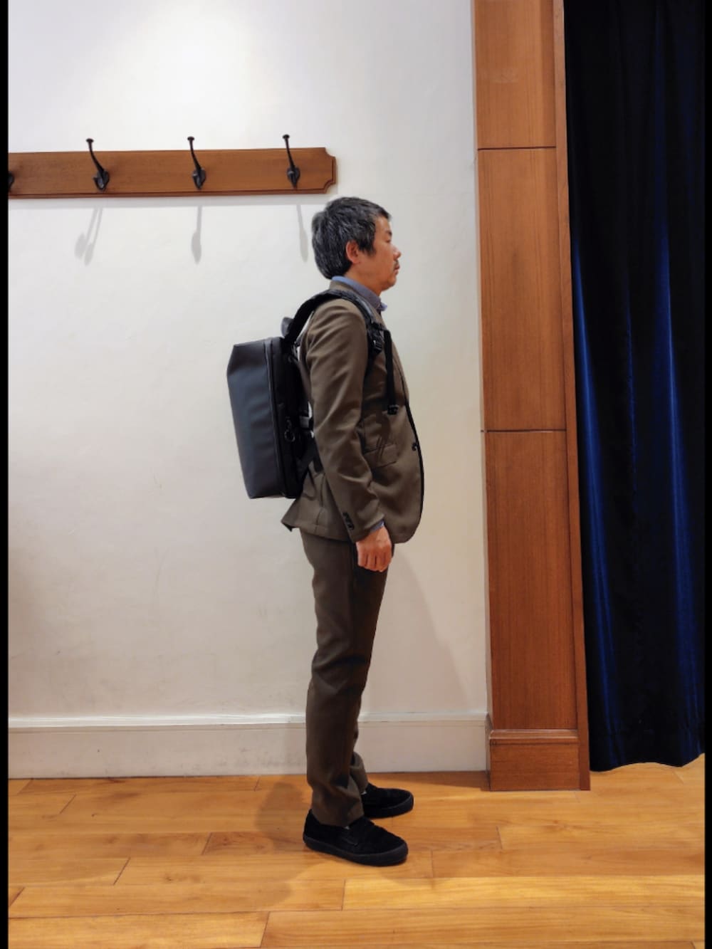 ブラック系のバックパック/リュック、グリーン系のテーラードジャケット、グリーン系のその他パンツを着用したメンズの春コーディネートの5枚目の写真