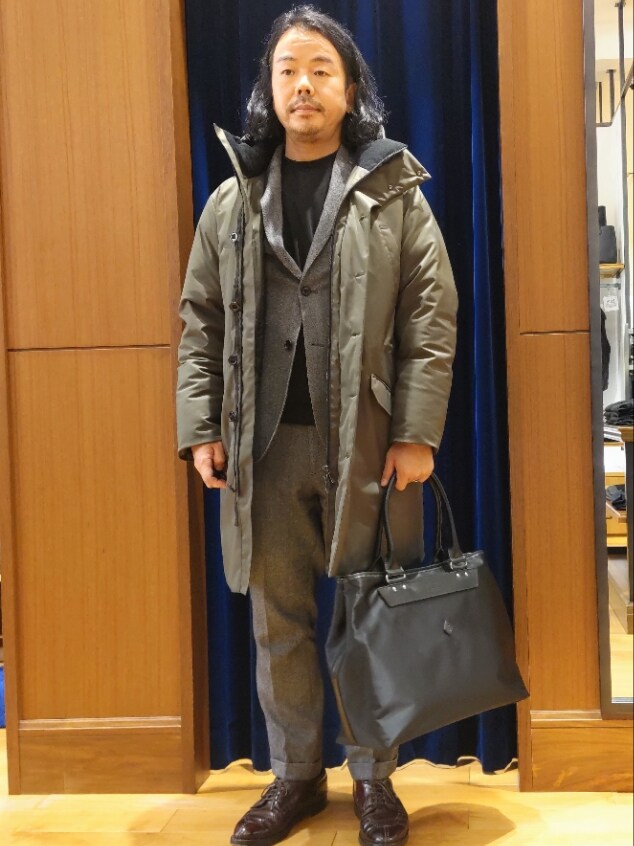 グリーン系のダウンジャケット/コート、グレー系のテーラードジャケット、グレー系のスラックスを着用したメンズの冬コーディネートの2枚目の写真