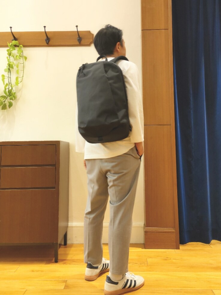 ホワイト系のTシャツ/カットソー、ブラック系のバックパック/リュック、グレー系のその他パンツを着用したメンズの春コーディネートの3枚目の写真