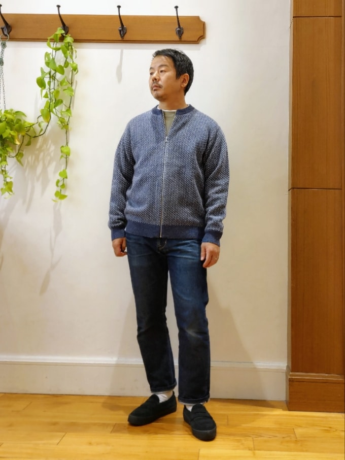 ブルー系のカーディガン/ボレロ、グリーン系のTシャツ/カットソー、ブラック系のスニーカーを着用したメンズの冬コーディネートの2枚目の写真