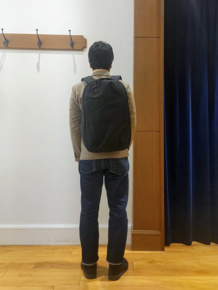 ベージュ系のテーラードジャケット、ブラック系のバックパック/リュックを着用したメンズの春コーディネートの6枚目の写真