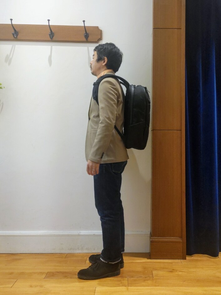 ベージュ系のテーラードジャケット、ブラック系のバックパック/リュックを着用したメンズの春コーディネートの5枚目の写真