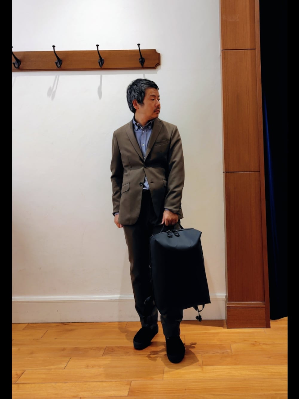 ブラック系のバックパック/リュック、グリーン系のテーラードジャケット、グリーン系のその他パンツを着用したメンズの春コーディネートの2枚目の写真