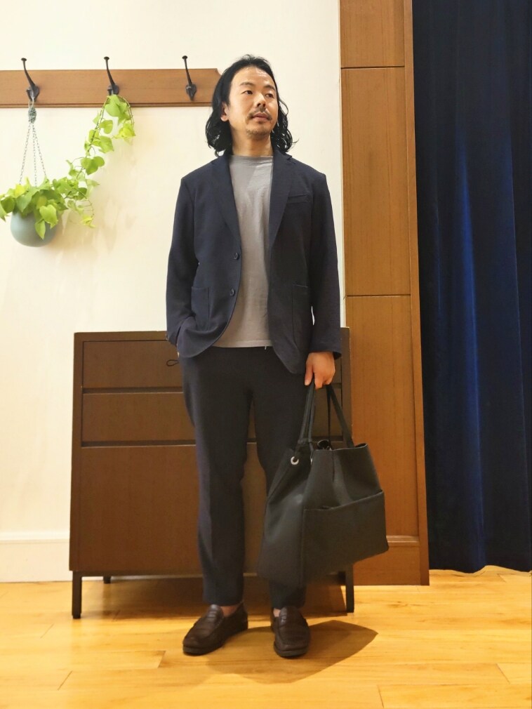 ブルー系のテーラードジャケット、ブルー系のその他パンツ、ブラック系のトートバッグを着用したメンズの春コーディネートの2枚目の写真