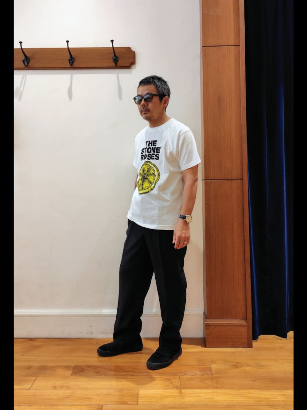 ホワイト系のTシャツ/カットソー、ブラック系のスラックス、ブラック系のサングラスを着用したメンズの春コーディネートの3枚目の写真