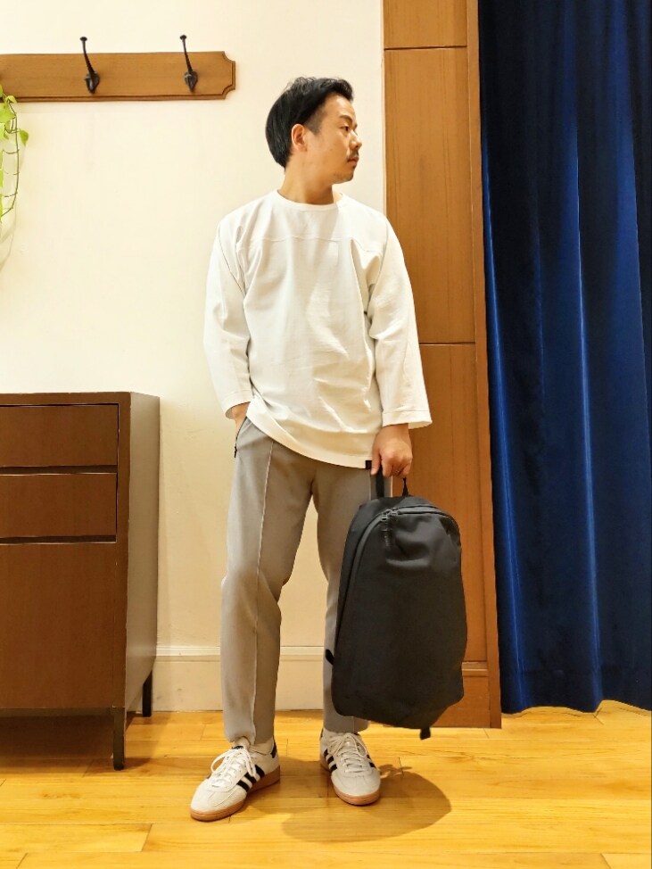 ホワイト系のTシャツ/カットソー、ブラック系のバックパック/リュック、グレー系のその他パンツを着用したメンズの春コーディネートの2枚目の写真