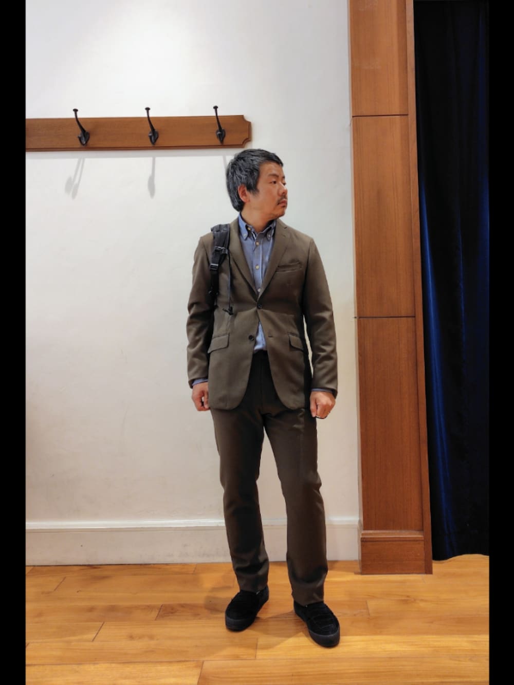 ブラック系のバックパック/リュック、グリーン系のテーラードジャケット、グリーン系のその他パンツを着用したメンズの春コーディネートの8枚目の写真