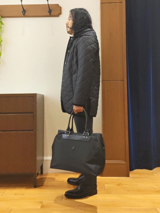 ブルー系のステンカラーコート、ブラック系のトートバッグ、ブラック系のドレスシューズを着用したメンズの秋コーディネートの5枚目の写真