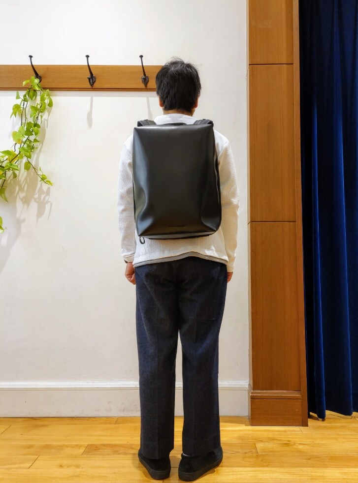 ホワイト系のTシャツ/カットソー、ブラック系のバックパック/リュック、ブルー系のデニムパンツを着用したメンズの冬コーディネートの3枚目の写真