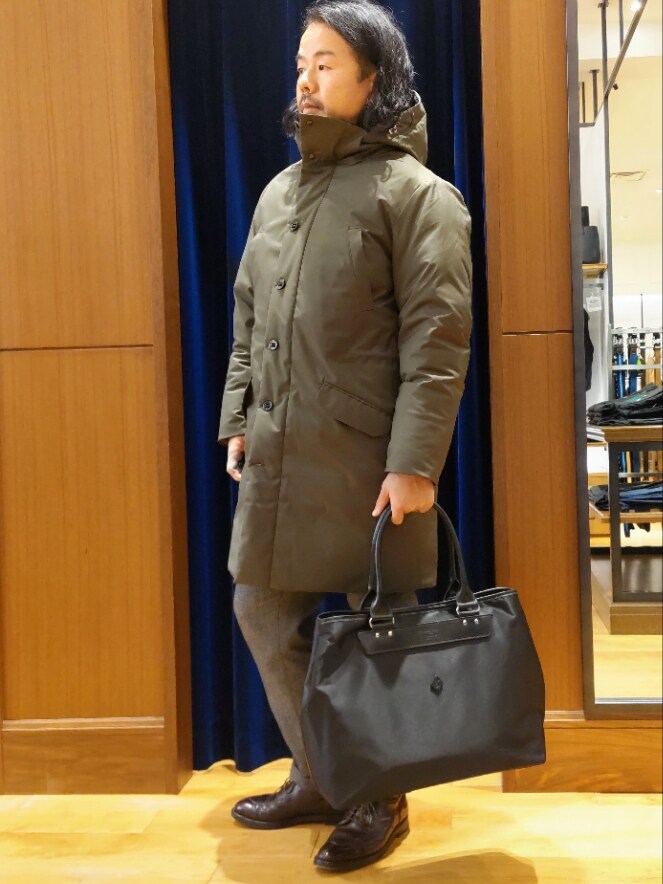 グリーン系のダウンジャケット/コート、グレー系のテーラードジャケット、グレー系のスラックスを着用したメンズの冬コーディネートの4枚目の写真