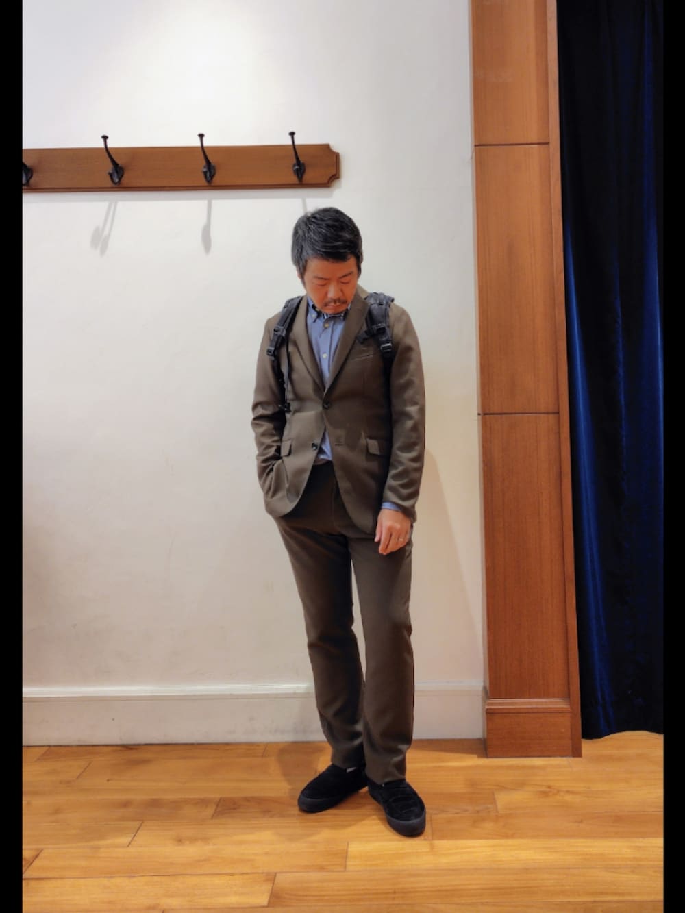 ブラック系のバックパック/リュック、グリーン系のテーラードジャケット、グリーン系のその他パンツを着用したメンズの春コーディネートの7枚目の写真