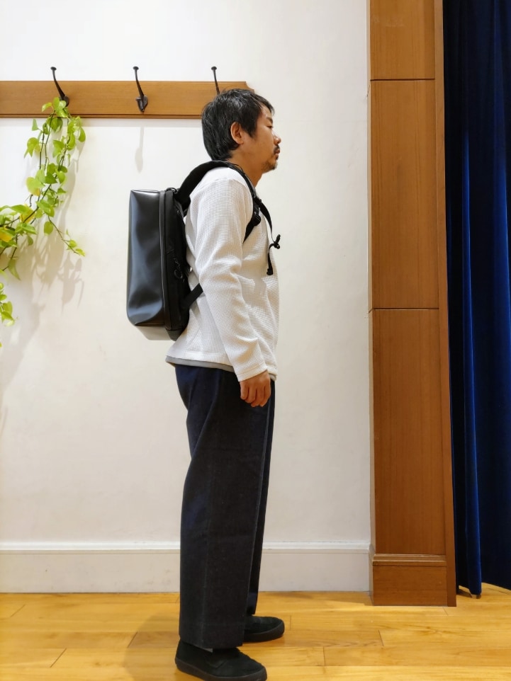 ホワイト系のTシャツ/カットソー、ブラック系のバックパック/リュック、ブルー系のデニムパンツを着用したメンズの冬コーディネートの4枚目の写真