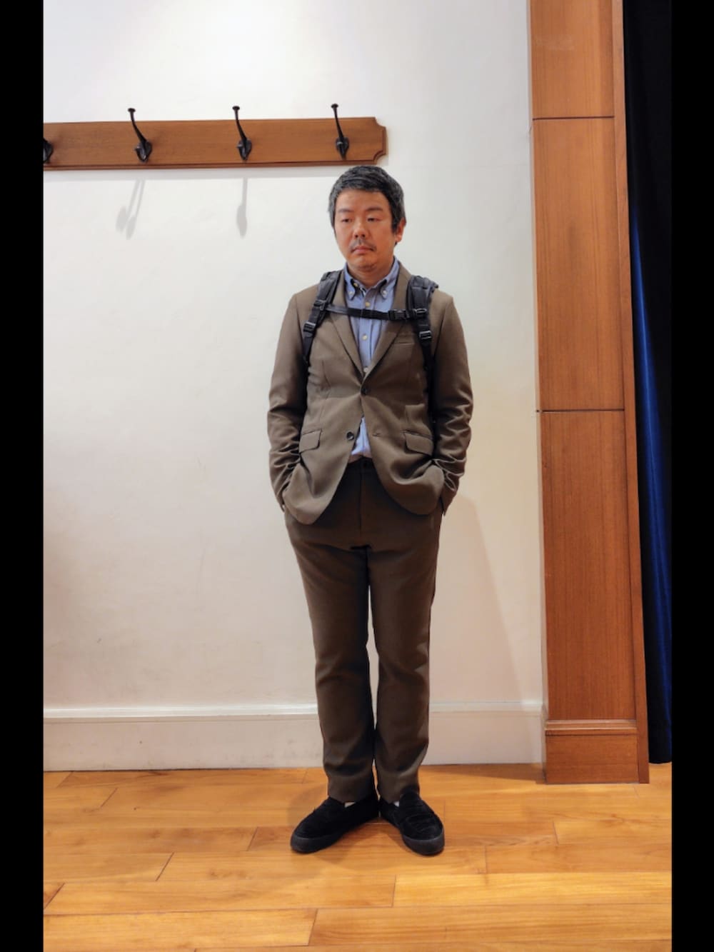 ブラック系のバックパック/リュック、グリーン系のテーラードジャケット、グリーン系のその他パンツを着用したメンズの春コーディネートの3枚目の写真