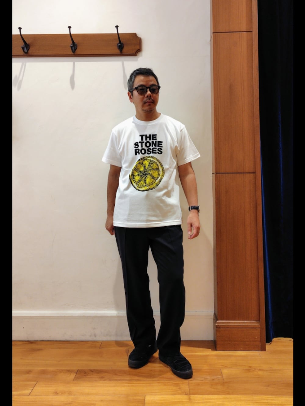 ホワイト系のTシャツ/カットソー、ブラック系のスラックス、ブラック系のサングラスを着用したメンズの春コーディネートの4枚目の写真